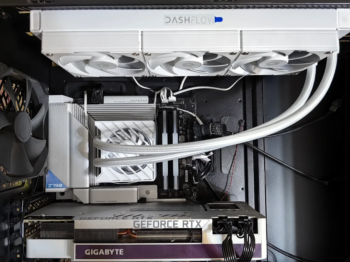 Interior de gabinete branco com radiador de water cooler de 360 mm instalado no topo e cooler a ar visível ao lado, com placa de vídeo GeForce RTX abaixo