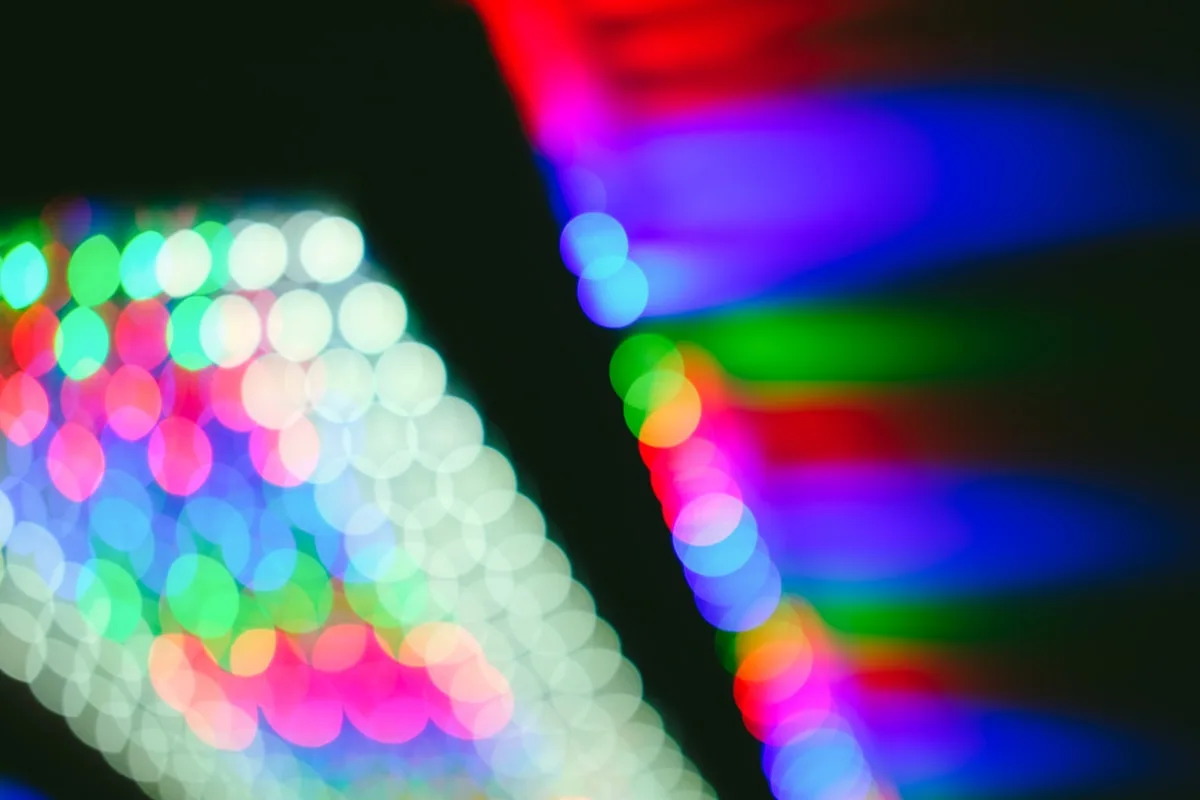 Luzes coloridas desfocadas em bokeh, remetendo à iluminação RGB de handhelds retrô premium