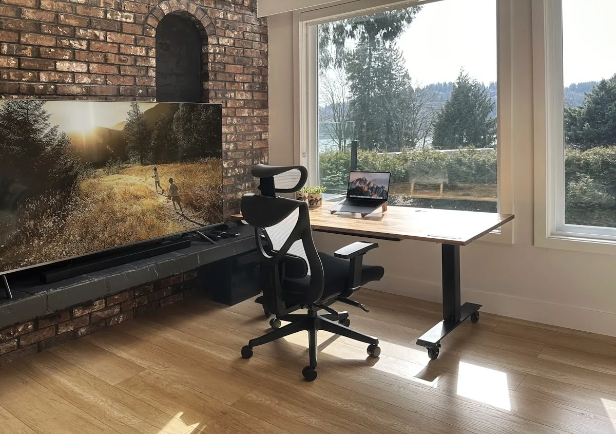 Home office com cadeira ergonômica de mesh mostrando postura correta com lombar apoiada