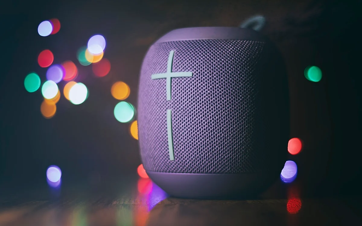 JBL portátil resistente à água — uso outdoor e piscina Pessoa usando caixa de som JBL portátil ao ar livre em atividade outdoor com água ao fundo