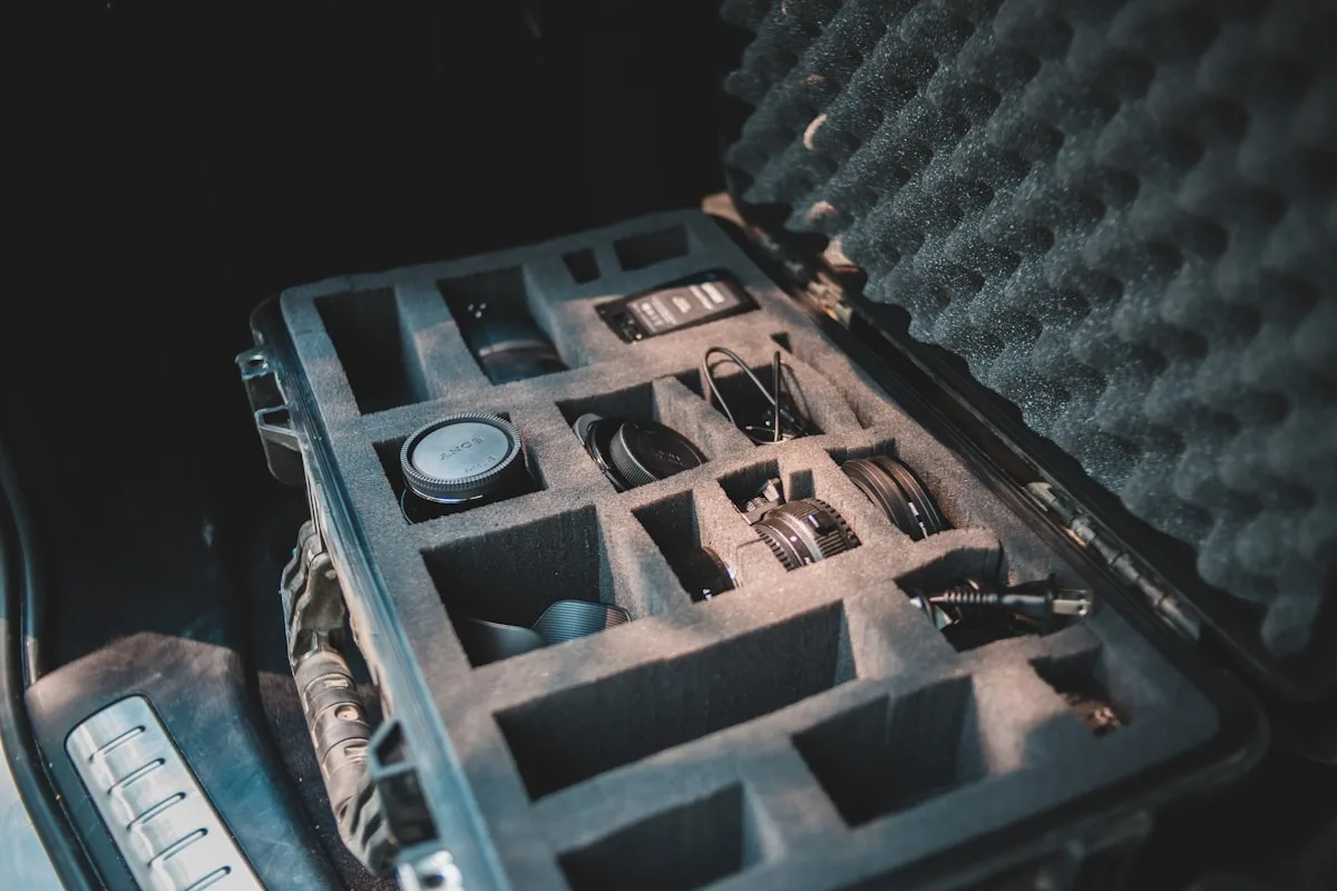 Case rígido preto com espuma recortada sob medida organizando equipamento sensível no porta-malas de um carro