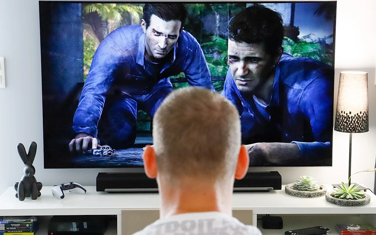 Cabo óptico Toslink sendo conectado à saída óptica digital de uma TV para soundbar