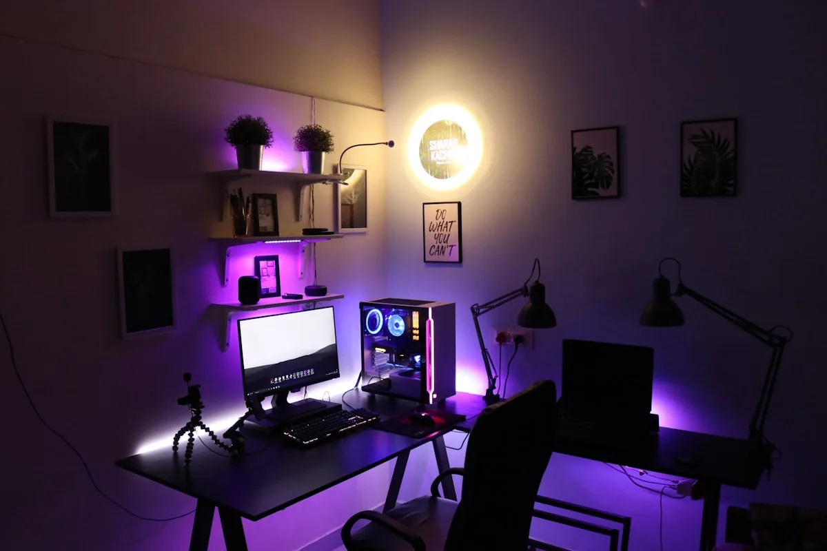 Setup de mesa gamer com monitor ultrawide curvo grande exibindo jogo de corrida com teclado e mouse à frente