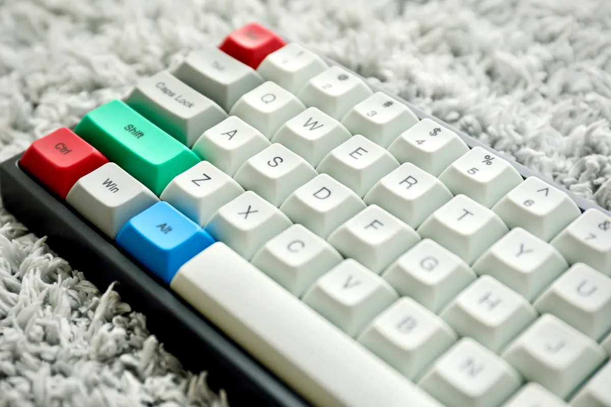Keycaps de teclado mecânico de molho em bacia com água morna e sabão neutro ao lado da chave puxadora