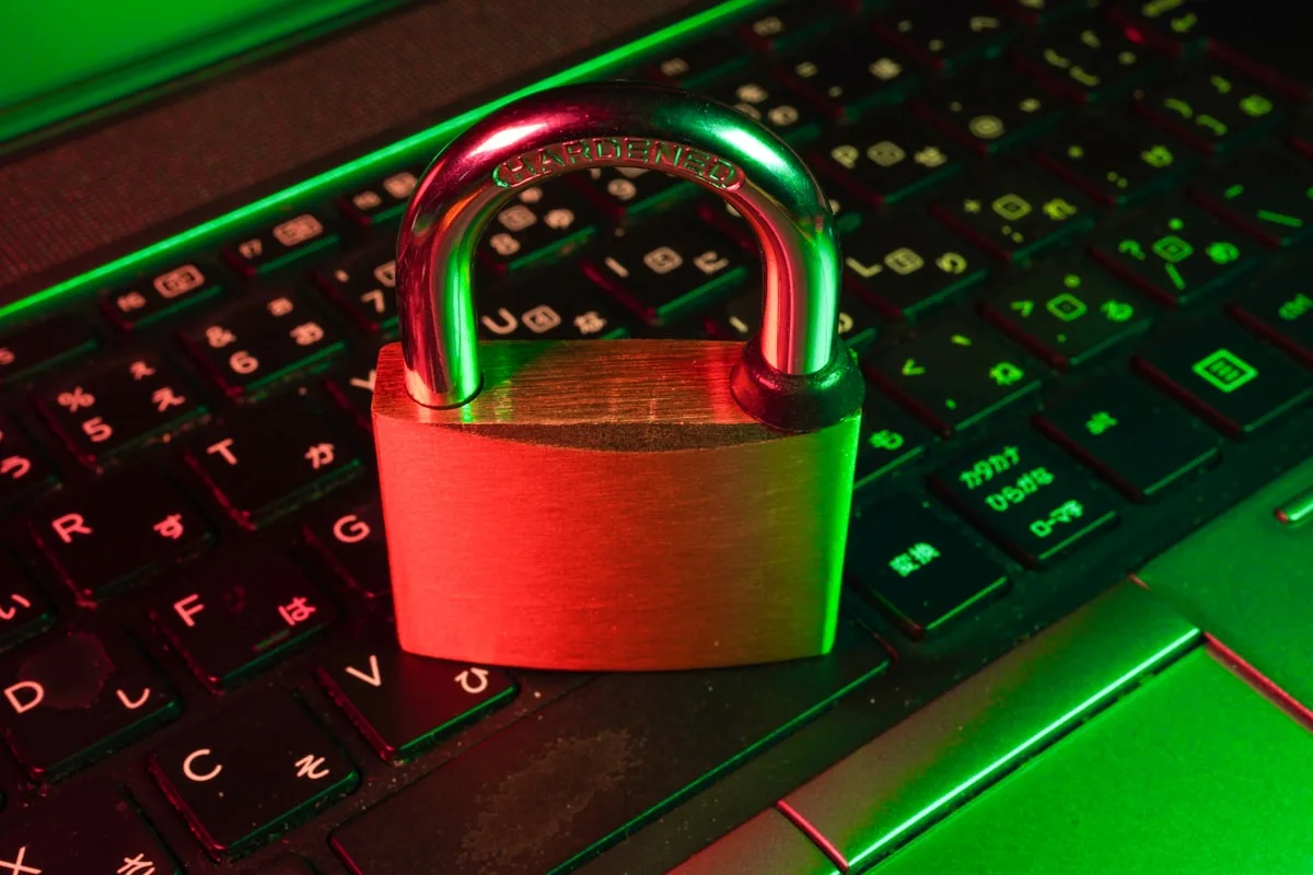 Cadeado de metal apoiado sobre um teclado gamer iluminado em vermelho e verde
