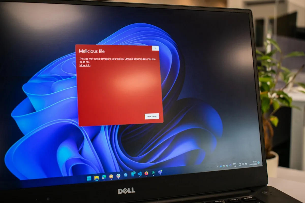 Notebook com alerta de arquivo malicioso na tela e botão para não executar o programa