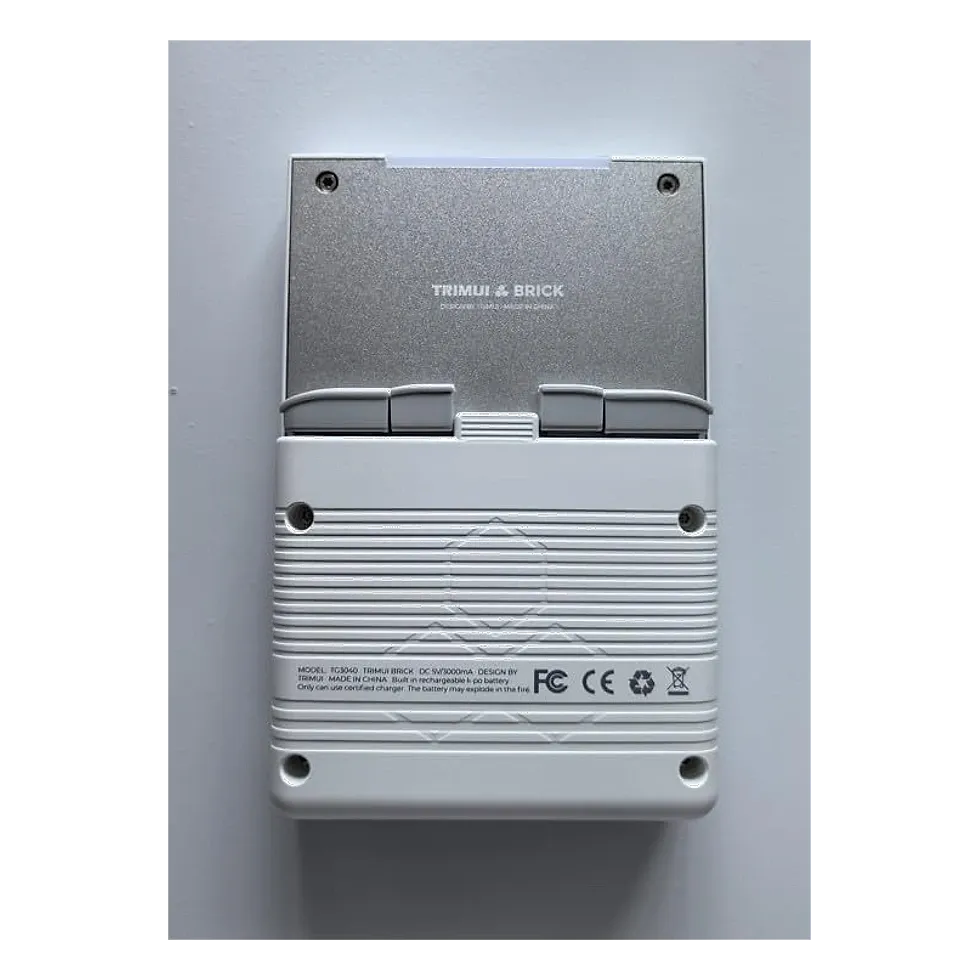 TRIMUI Brick visto de trás, com a marca gravada na tampa metálica e ficha técnica de bateria