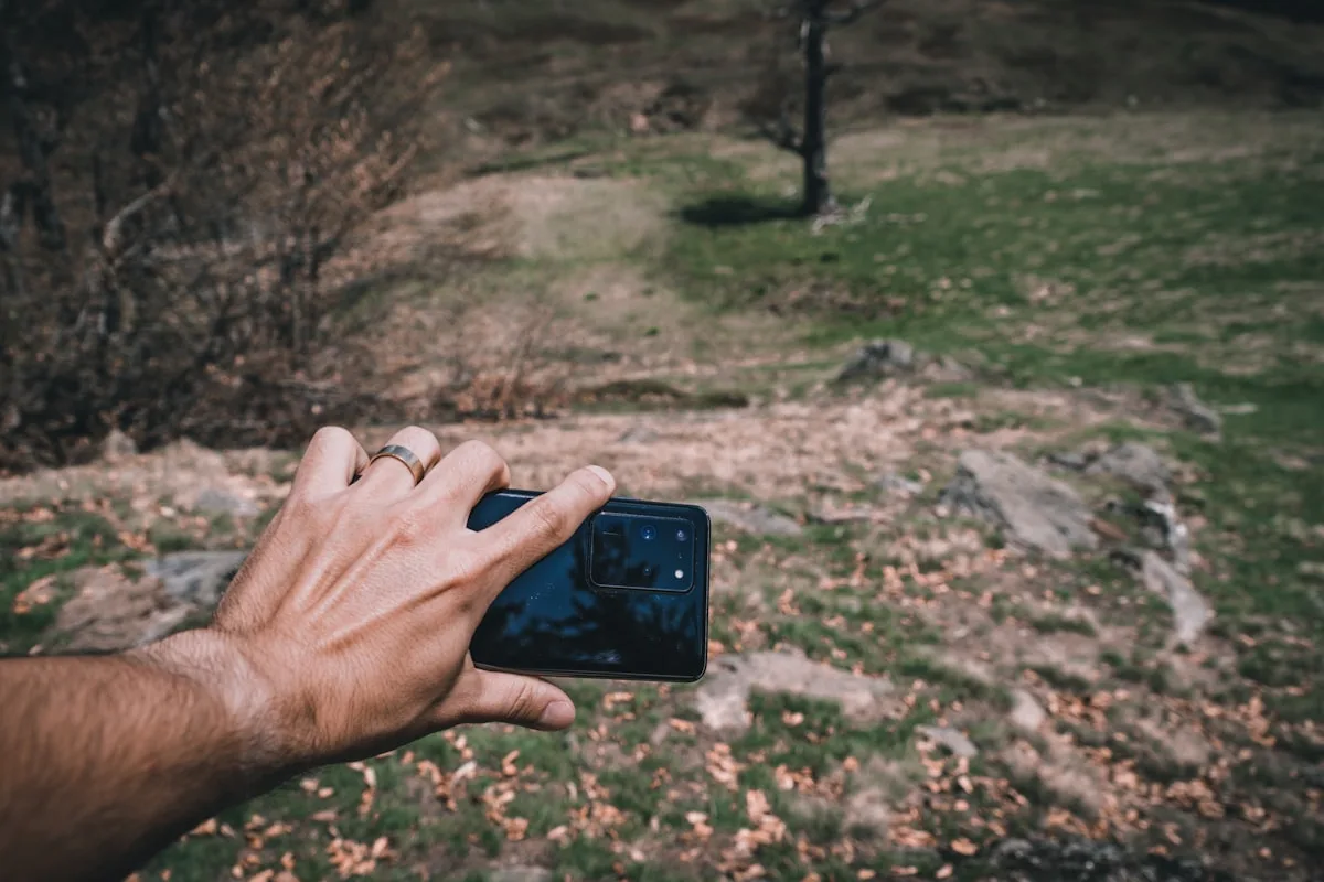 Mão segurando um celular ao ar livre, alternativa mais barata a um handheld retrô dedicado