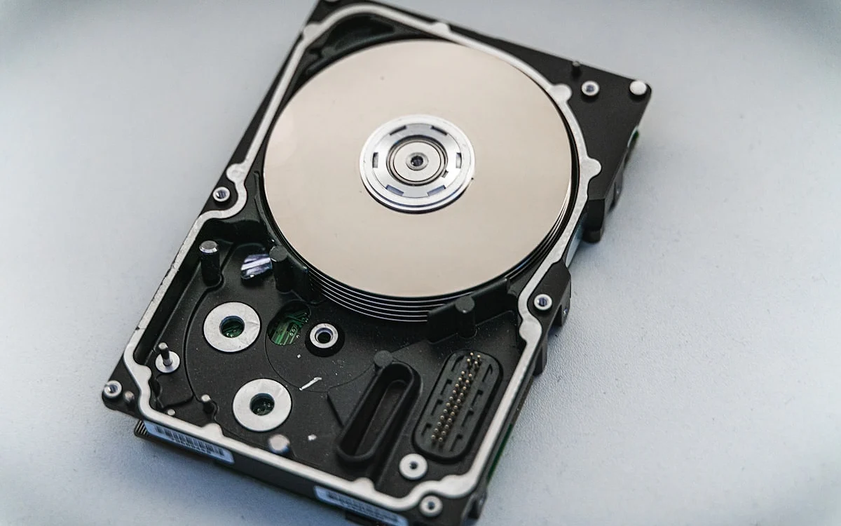 HD externo portátil conectado por cabo USB a um notebook sobre uma mesa