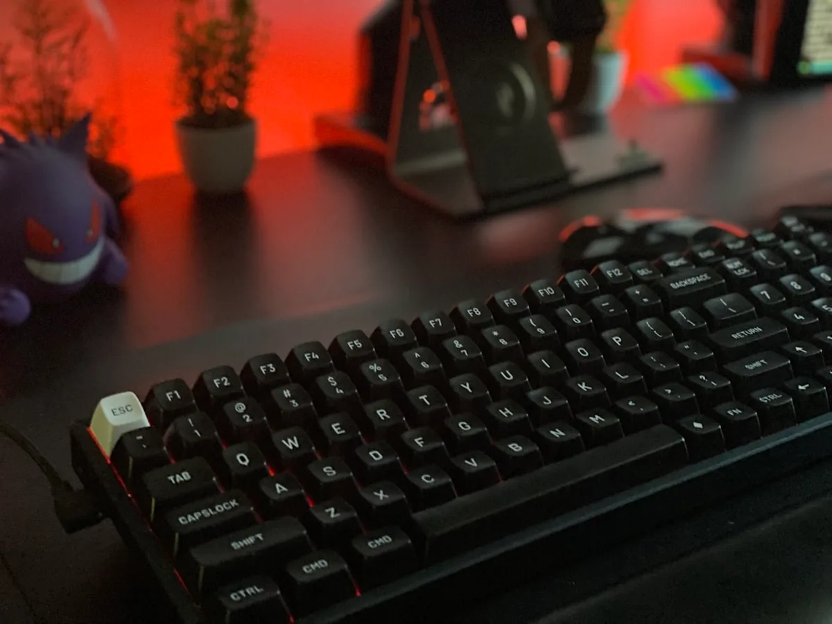 Close das teclas de teclado mecânico com RGB por tecla vazando intenso pela base exposta