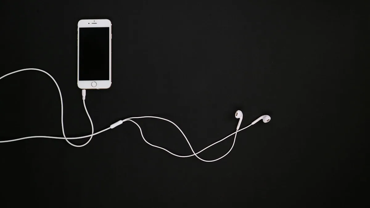 Celular branco ao lado de fones intra-auriculares com fio sobre fundo preto