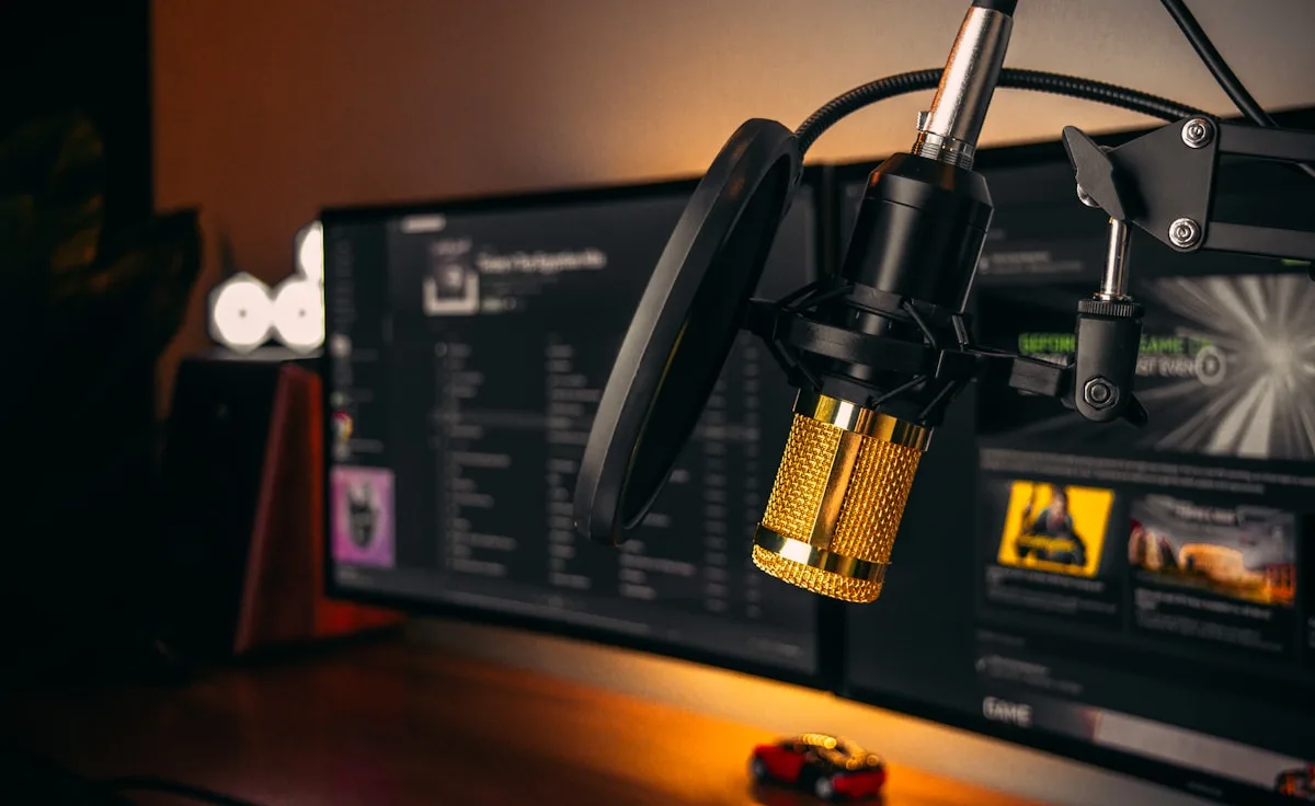 Microfone USB condensador em setup de streaming com luz de fundo azul em mesa gamer
