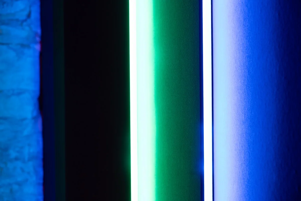 Fita de LED em close-up mostrando cores azul, verde e branca lado a lado na parede