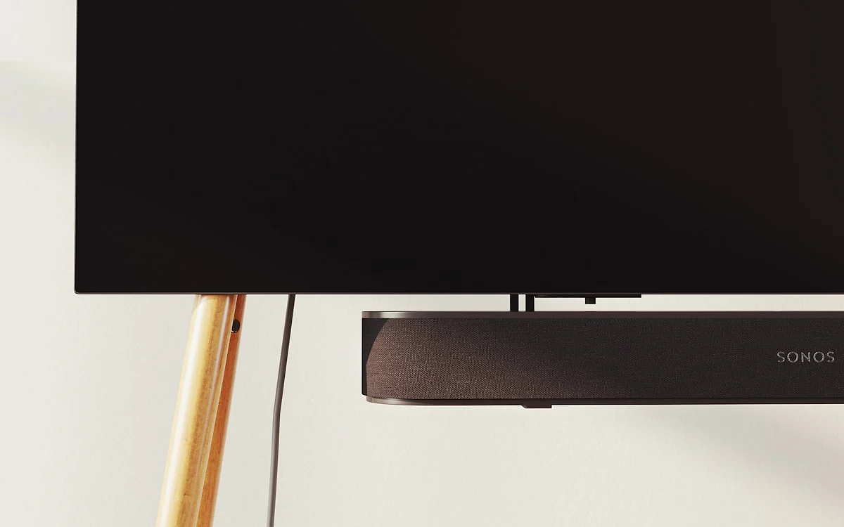 Subwoofer sem fio de soundbar posicionado ao lado de rack de TV em ambiente residencial