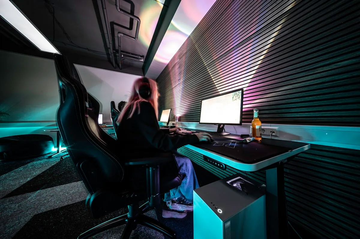 Mesa gamer com iluminação RGB e monitor num setup doméstico à noite