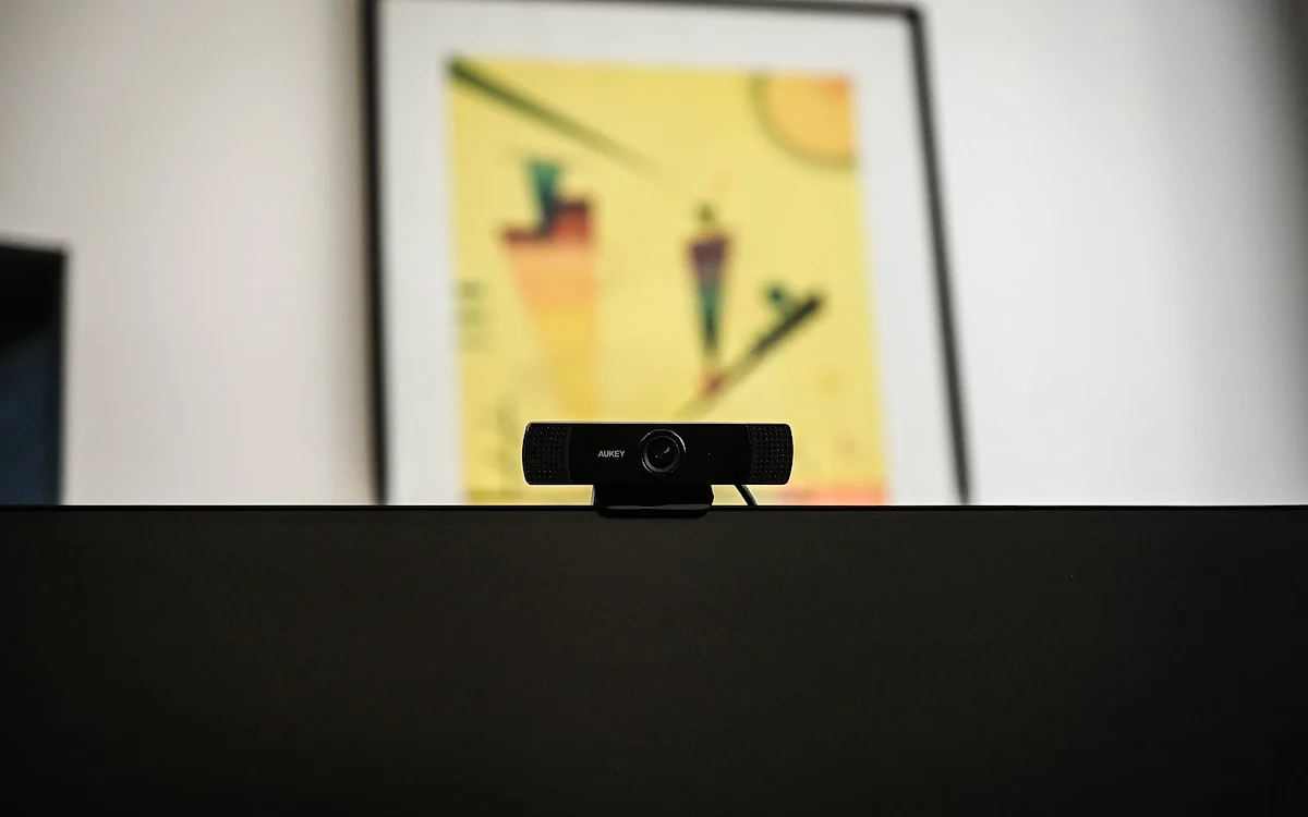 Setup de live streaming com iluminação de janela ao fundo e monitor em home office