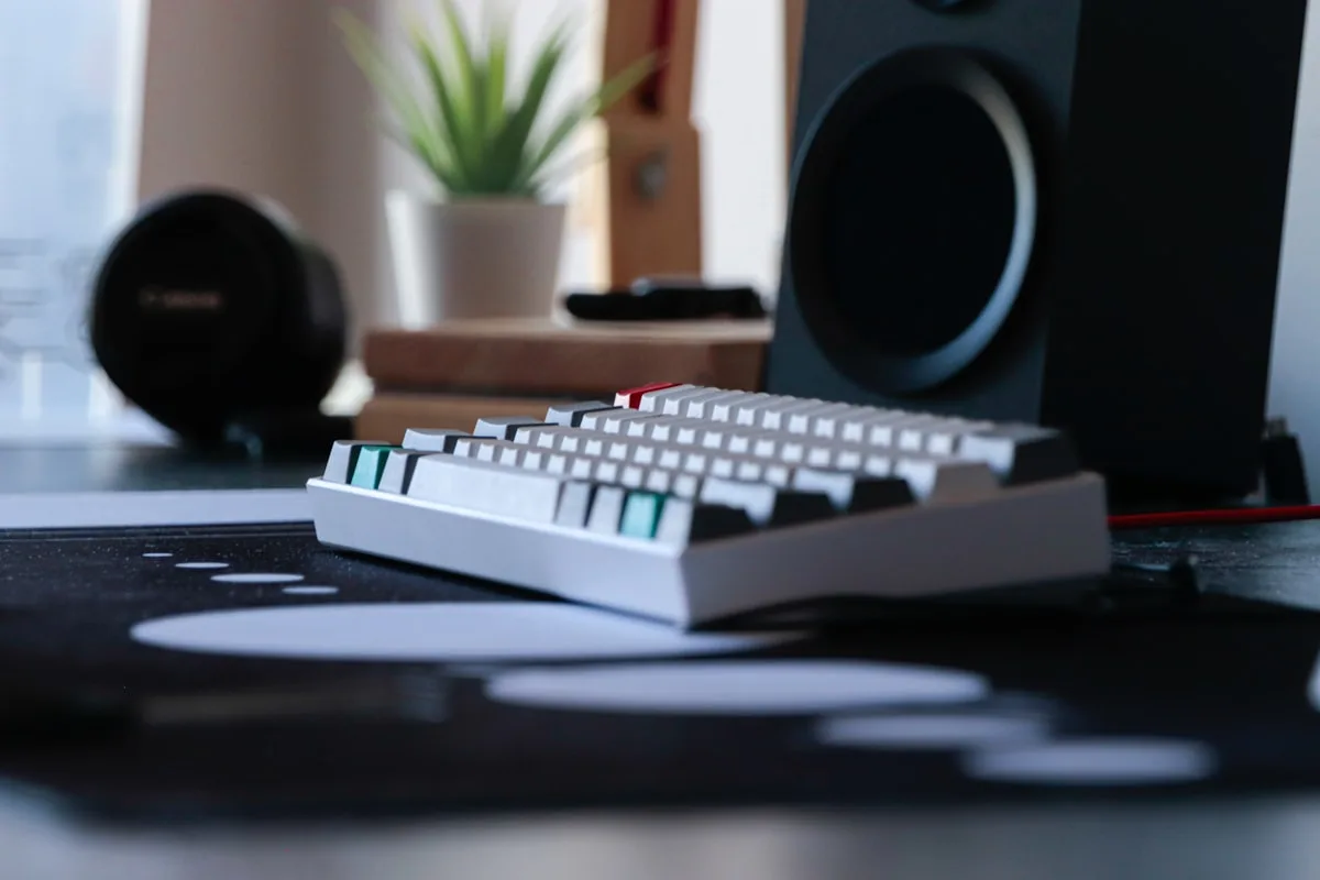 Teclado mecânico full-size com top case de alumínio escovado escuro visto em ângulo