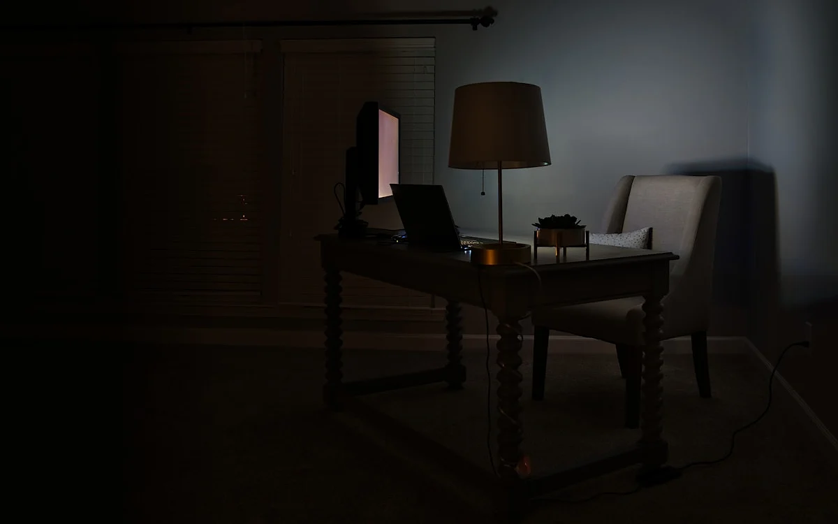 Setup gamer com mesa preta ampla, monitor, teclado mecânico e mouse em ambiente escuro