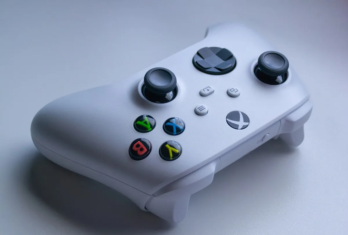 Melhores controles para PC até R$ 150 — com fio e plug and play em 2026 Controle gamepad com fio USB conectado a computador gamer em setup de entrada com jogos na tela