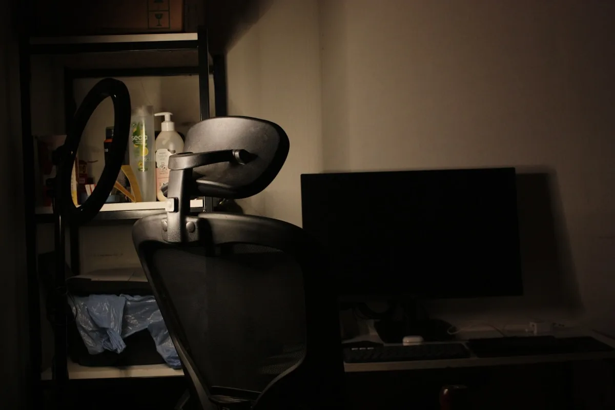 Setup gamer no escuro esperando iluminação de fundo Cadeira gamer e monitor apagado em cantinho de quarto escuro com ring light ao fundo