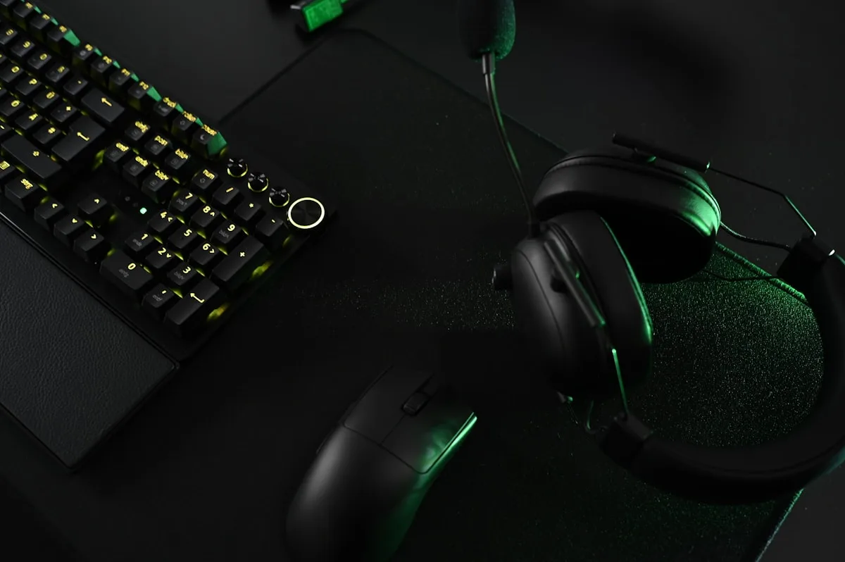 Fones intra-auriculares com fio ao lado de controle e teclado em setup gamer econômico