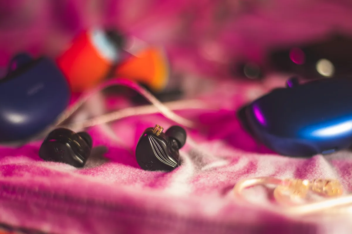 Monitores intra-auriculares com cabo sobre mesa de setup para games e produção musical
