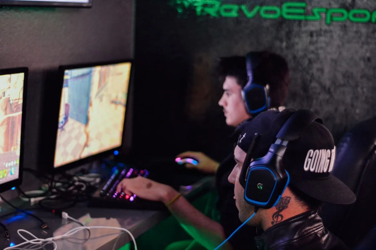 Dois jogadores em computadores durante partida competitiva de FPS em um ambiente de esports
