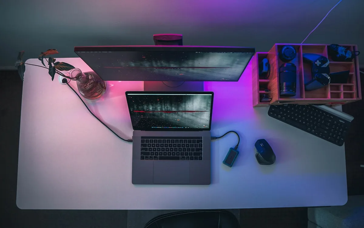 Fones in-ear gamer com iluminação RGB sobre mesa com teclado e controle