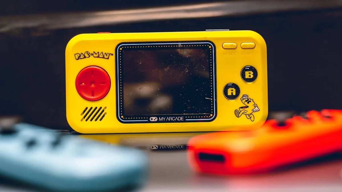 Handheld retrô amarelo estilo arcade com tela quadrada e D-pad vermelho em destaque
