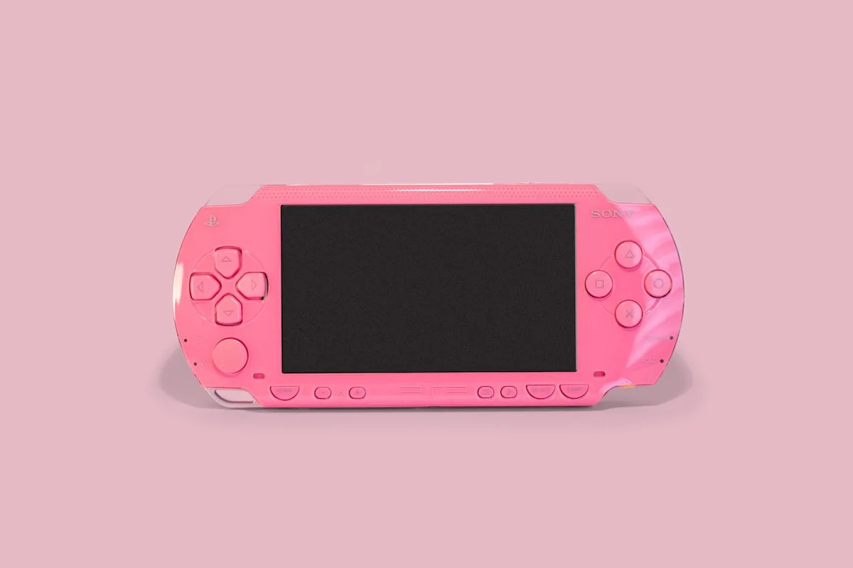 PlayStation Portátil rosa com tela grande desligada sobre fundo rosa claro