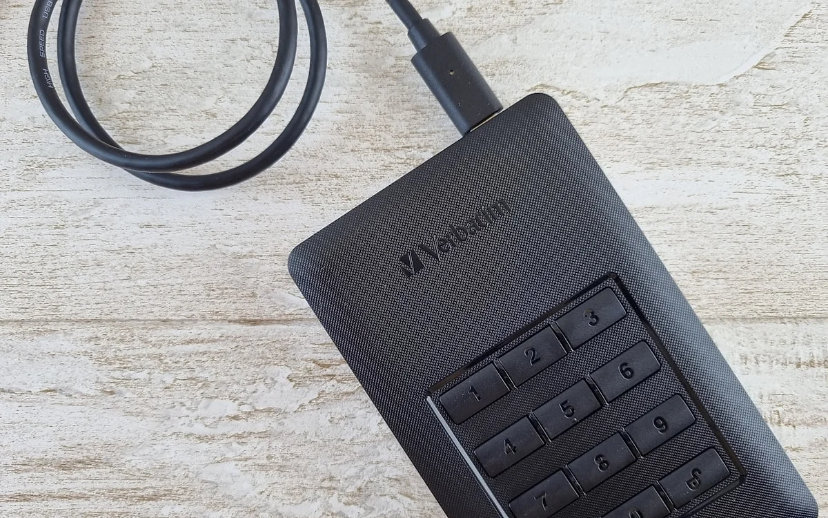 HD externo portátil conectado por cabo USB a um notebook em mesa de trabalho