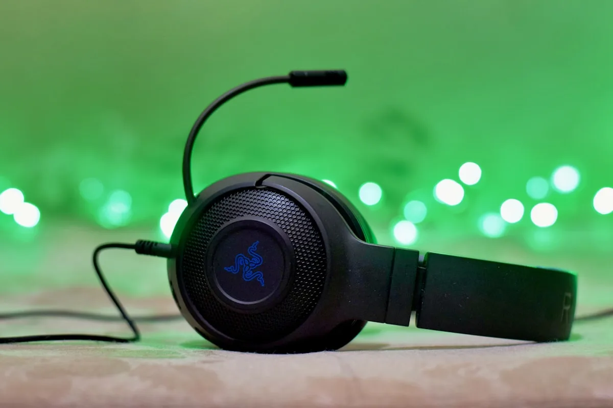Headset gamer over-ear preto com microfone destacável sobre mousepad RGB