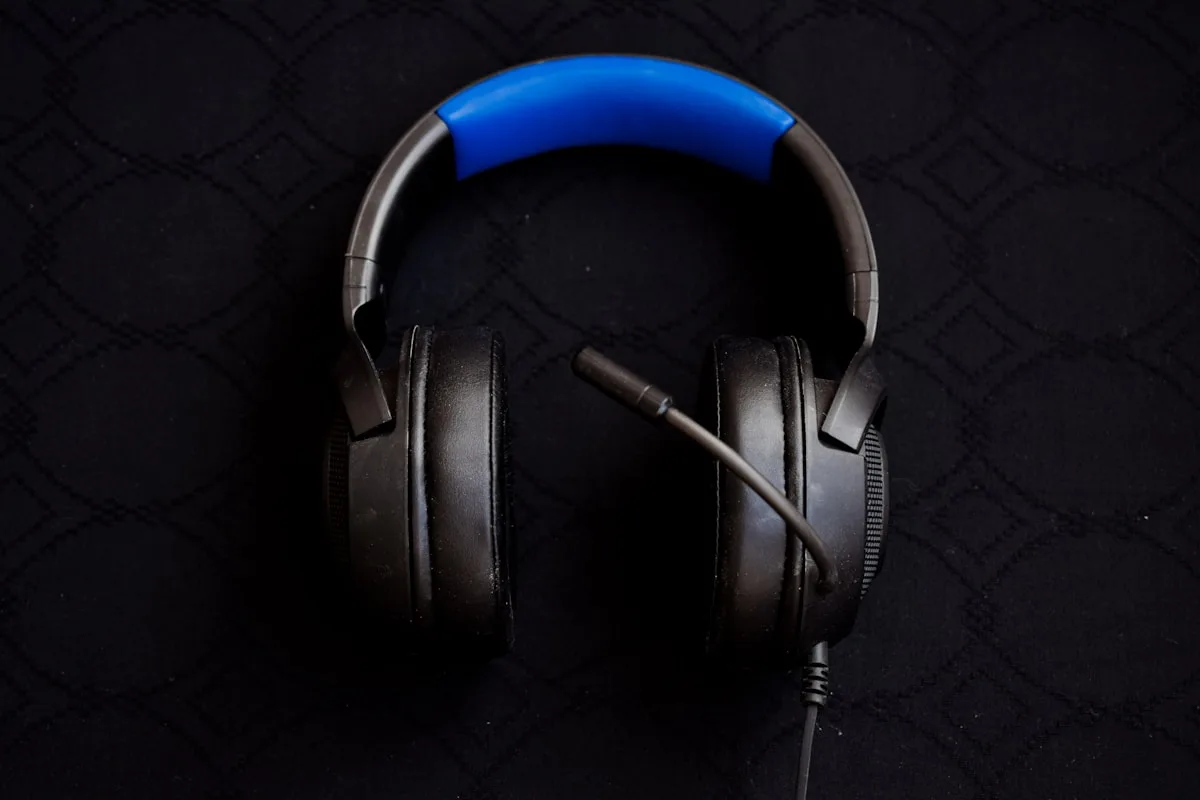 Setup gamer com monitor curvo, teclado RGB e headset preto sobre suporte