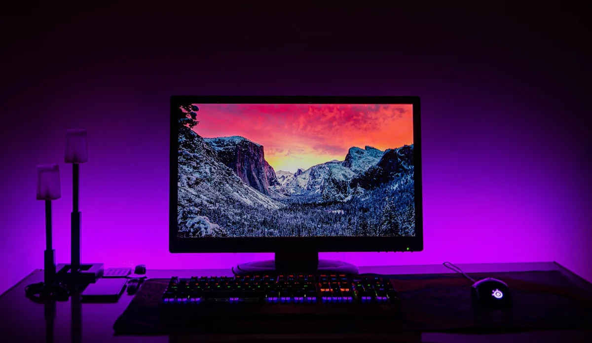 Setup com luz de fundo bem calibrada Setup com monitor e teclado iluminados por luz ambiente suave em tom neutro durante a noite