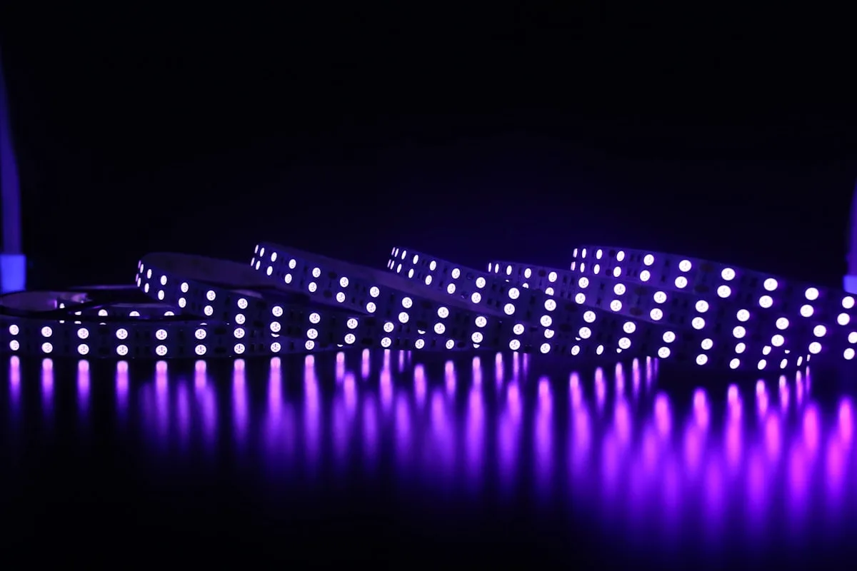 Fita de LED roxa enrolada com reflexo forte na superfície abaixo em ambiente escuro