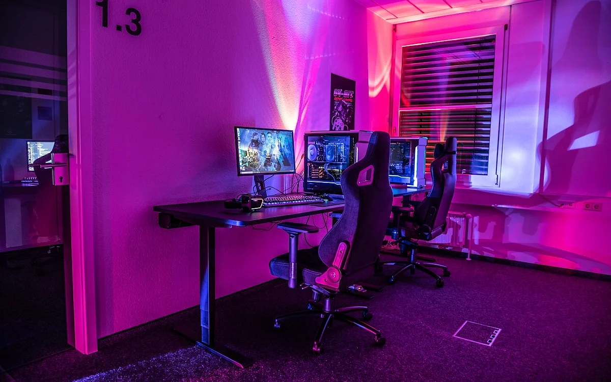 Critérios de escolha de mesa gamer — frame, tampo e compartimentos Detalhe de frame de aço de mesa gamer com passagem de cabo e tampo em MDF — foco na estrutura