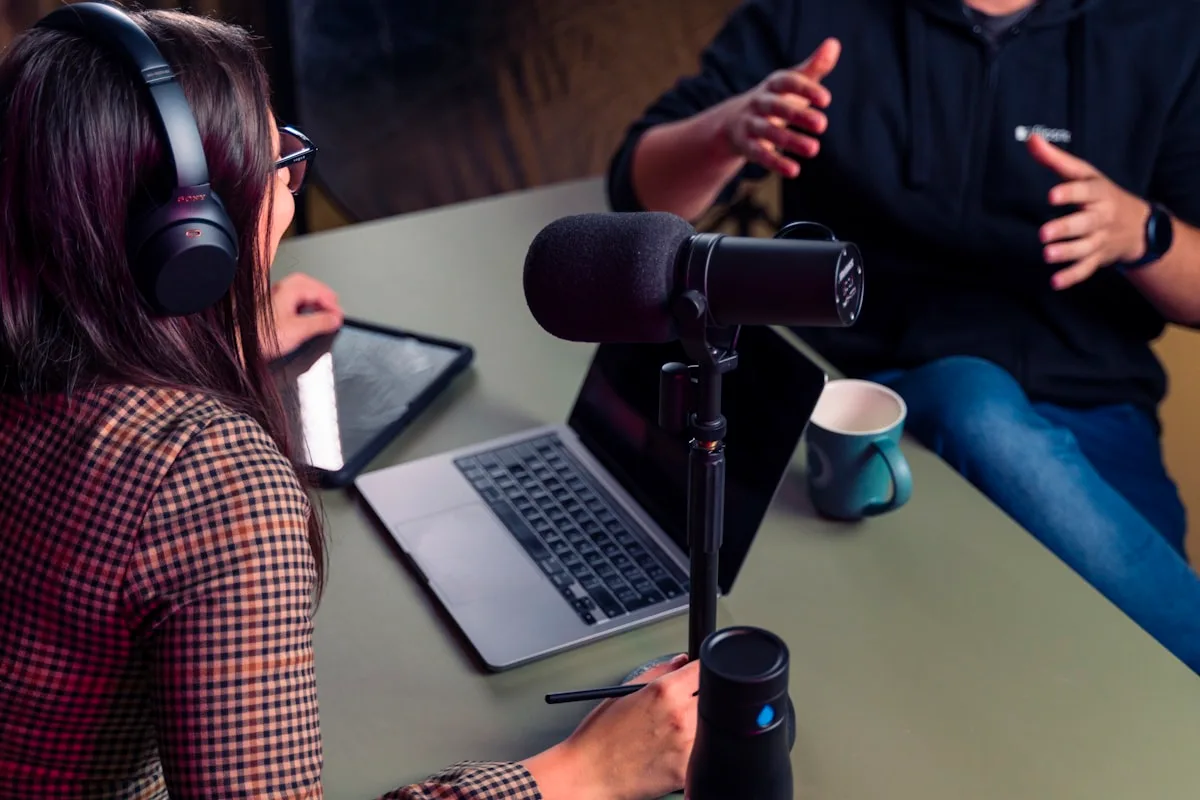 Setup de podcast com microfone XLR, interface de áudio e braço articulado em mesa de estúdio caseiro