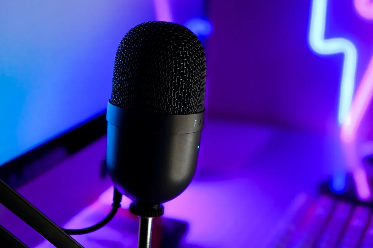 Como escolher microfone para streaming Setup de streaming com microfone dinâmico em braço articulado, interface de áudio e iluminação de fundo