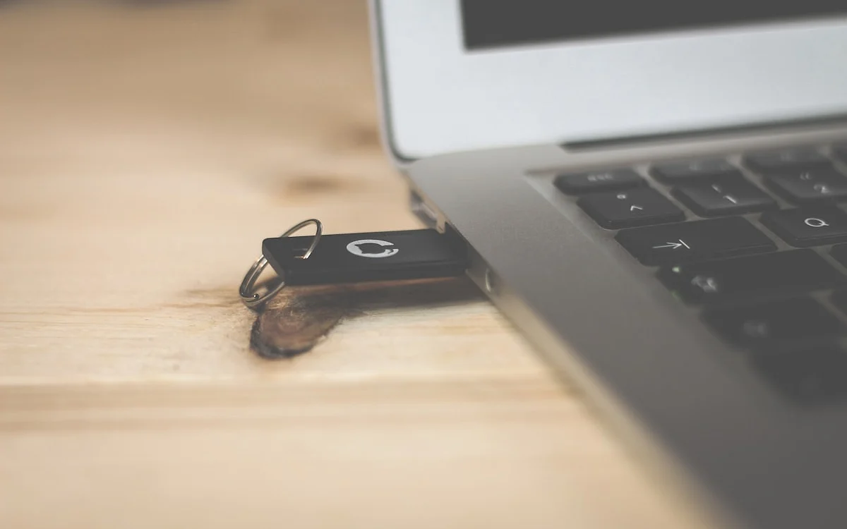 Pen drive USB-C conectado simultaneamente a um smartphone e a um notebook
