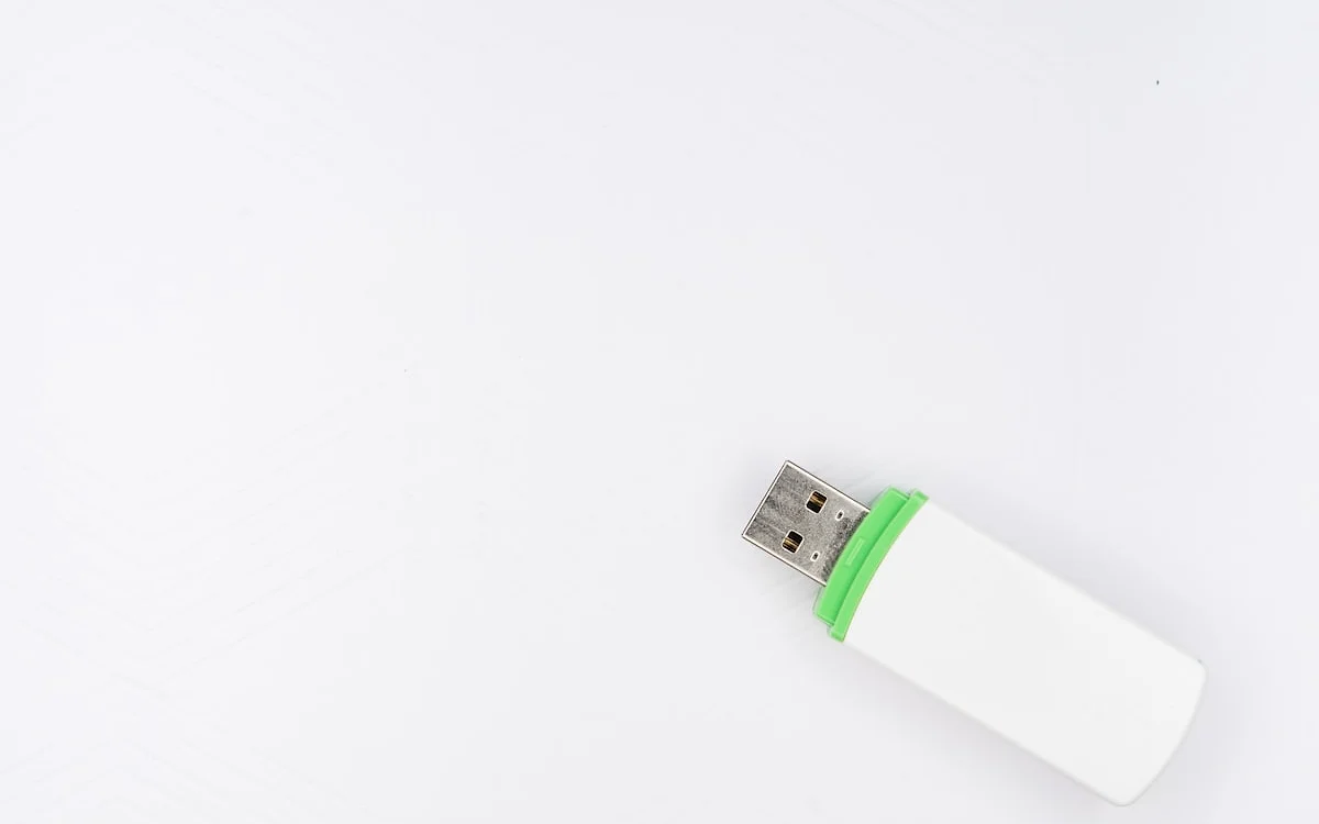 Pendrive USB 3.2 metálico conectado a uma porta azul de notebook durante transferência de arquivos