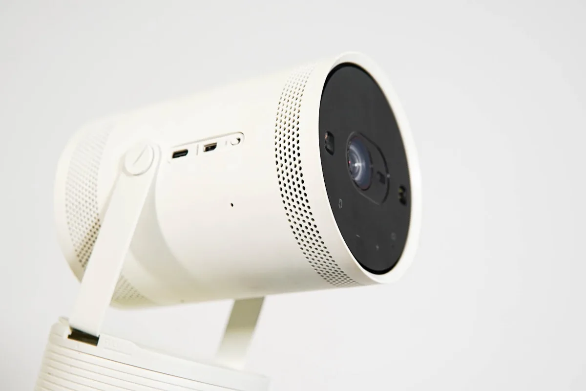 Projetor LG CineBeam em still de conectividade Projetor cilíndrico branco em close-up mostrando lente e portas de conexão