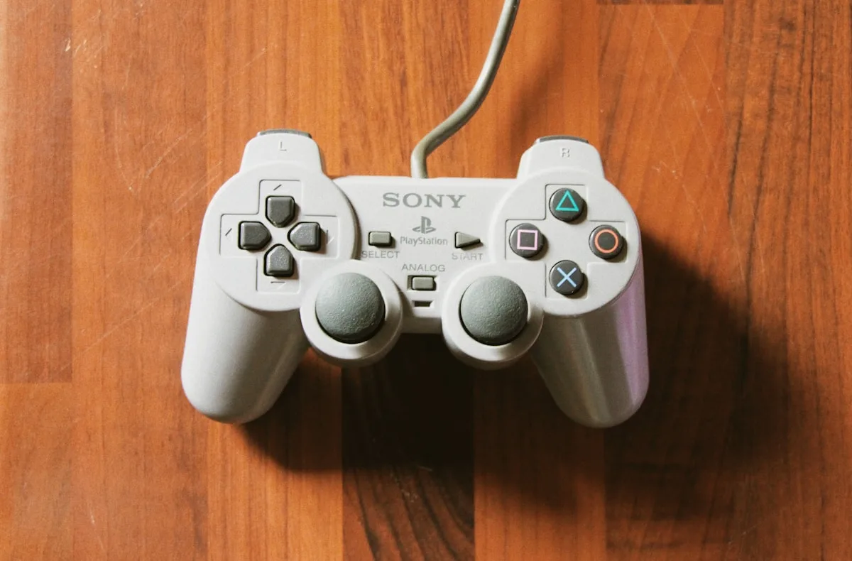 Configuração de projetor e PS5 para jogar em tela grande Controle PlayStation branco com fio sobre mesa de madeira em foco de botões