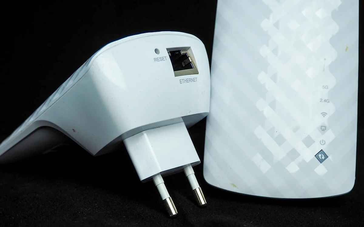 Ranking dos melhores repetidores de sinal Wi-Fi em 2026 Repetidor de sinal Wi-Fi instalado numa tomada de corredor perto de um cômodo distante do roteador