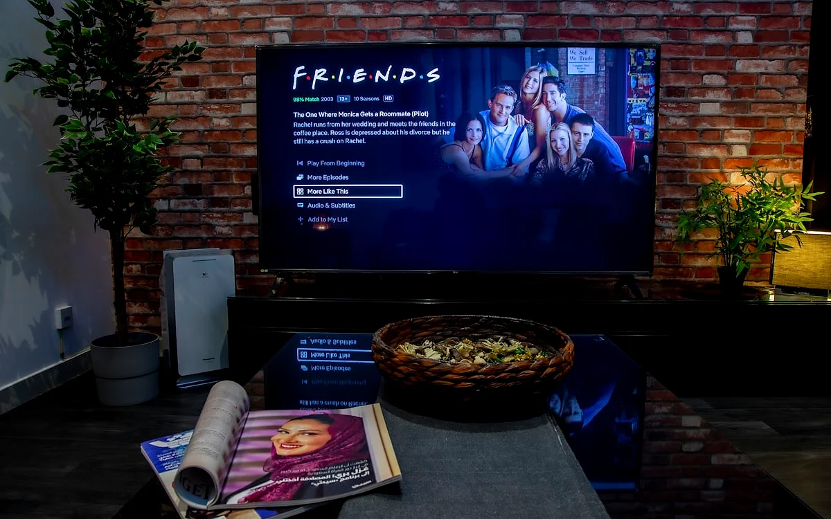 Ranking soundbar até R$ 1.000 em 2026 Soundbar com subwoofer sem fio posicionada abaixo de TV em sala de estar com móvel de madeira