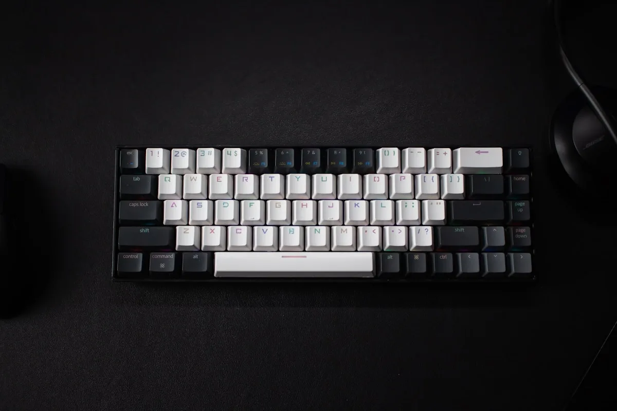 Teclado mecânico 60% de alumínio visto de cima ao lado de um mouse em mesa de setup