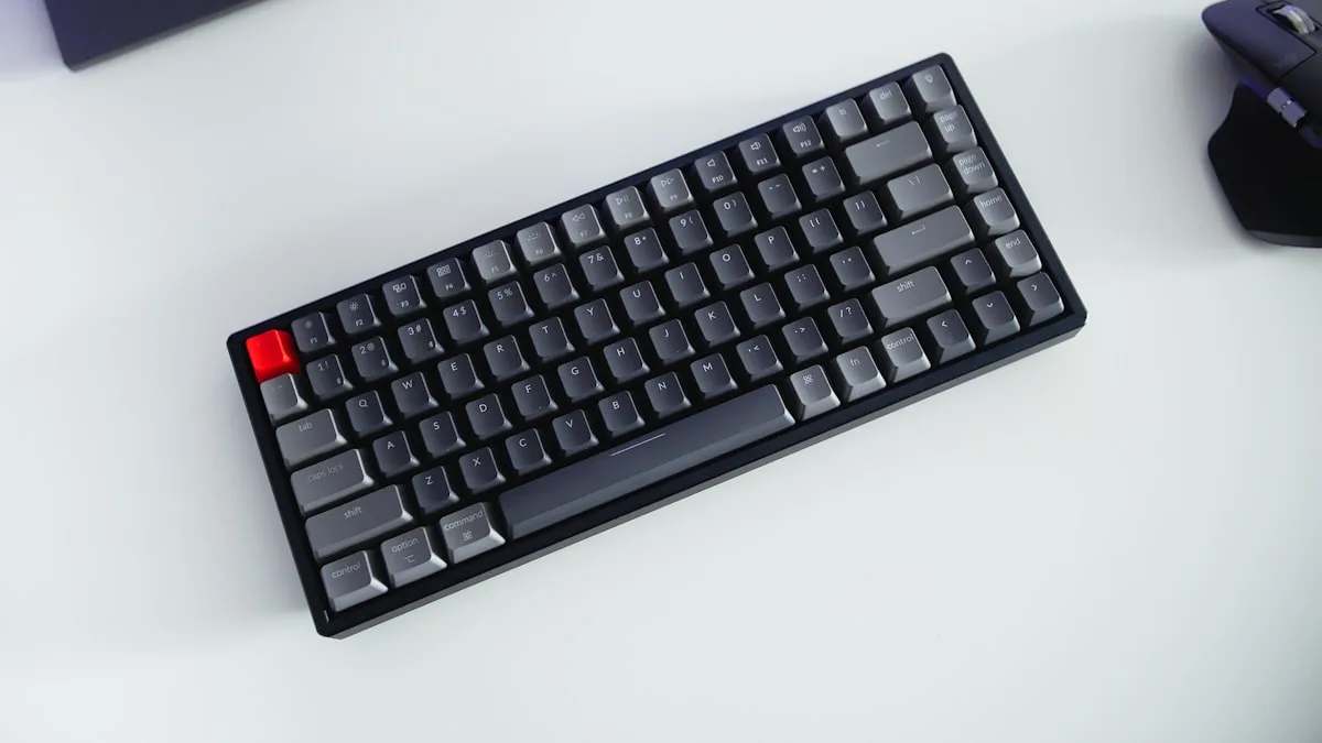 Teclado mecânico de alumínio com keycaps PBT visto de cima em mesa de setup