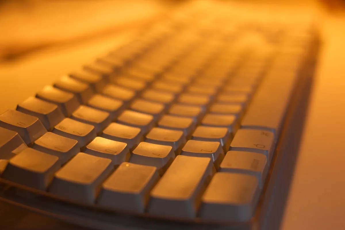 Teclado mecânico com switches silenciosos visto de cima em mesa de home office