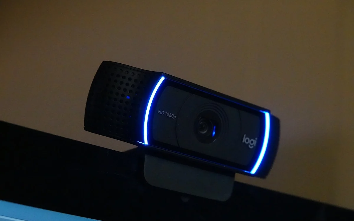 Setup de streamer com webcam 4K e iluminação profissional Setup de streamer com webcam 4K sobre monitor, microfone condensador e iluminação lateral profissional