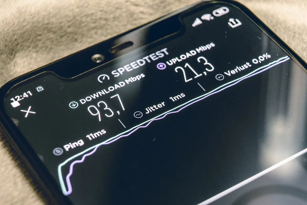 Smartphone preto exibindo aplicativo de teste de velocidade