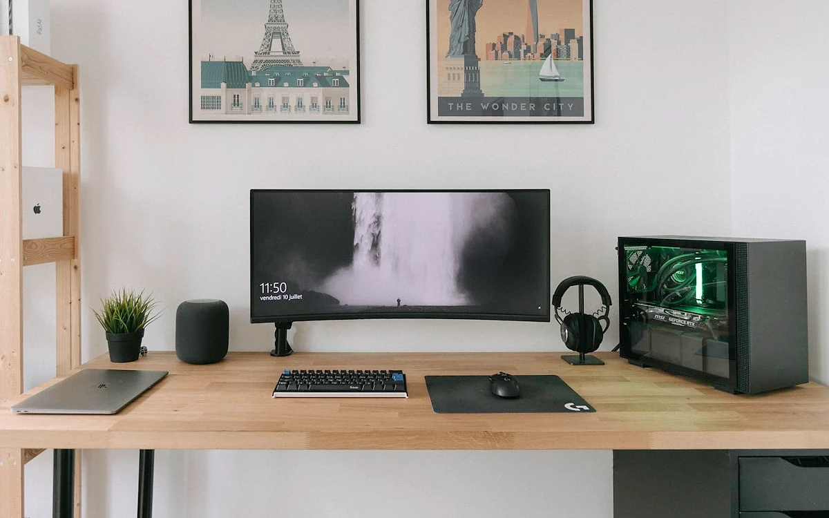 Mesa gamer vale a pena para setups com múltiplos periféricos Mesa gamer com mousepad grande, teclado mecânico e dois monitores em setup organizado